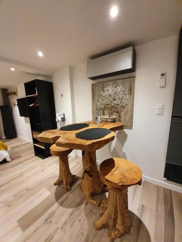a wooden table and two stools in a room at Appartements C'Home un charme in Lannion