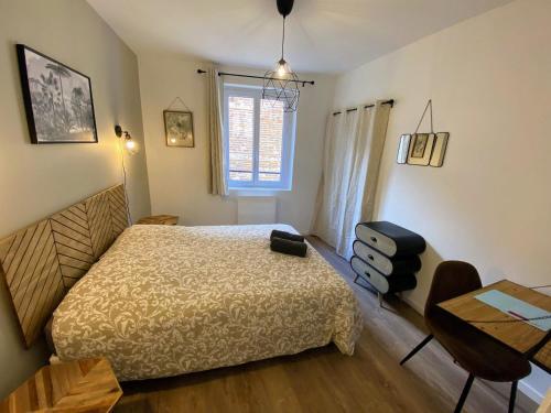 ein Schlafzimmer mit Bett, Schreibtisch und Fenster in der Unterkunft BALCON SUR LE MONDE - T2 COEUR DE VILLE in Agen