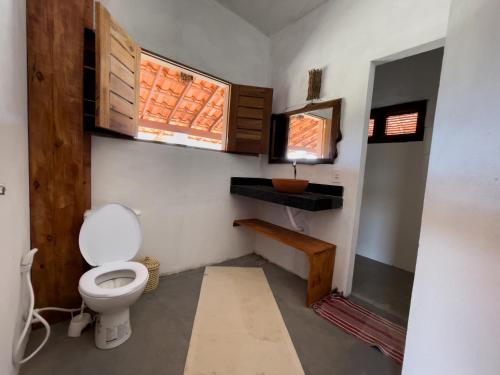 ein kleines Badezimmer mit Toilette und Fenster in der Unterkunft White House-Kite AliCori , Macapa' in Luis Correia