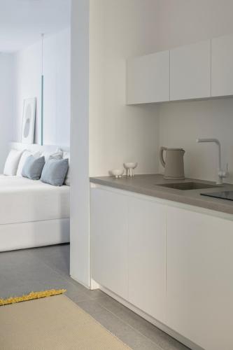 a kitchen with white cabinets and a bed at Villa Mimaze Minimalist Living in Elounda