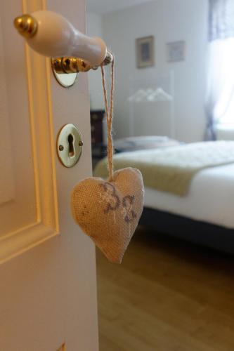 a heart hanging from the door of a bedroom at Bois de Cadène in Saint-Pierre-de-Buzet
