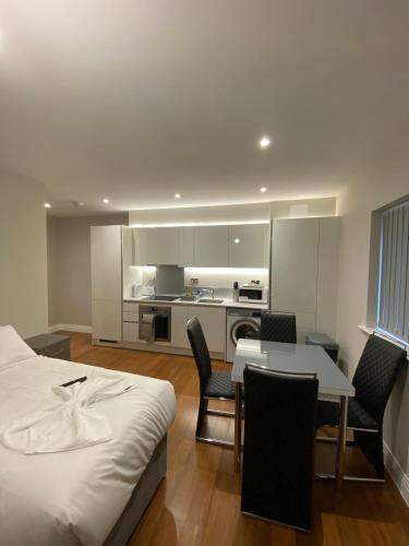 a bedroom with a bed and a table and chairs at Buckingham Apartments in High Wycombe
