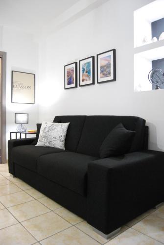 a black couch sitting in a living room at Etnea 365 Apartment in Catania
