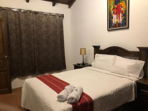 a bedroom with a bed with towels on it at Hotel Mansion Del Rey in Antigua Guatemala