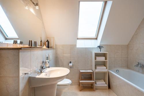 a bathroom with a sink and a toilet and a bath tub at Ferienwohnung im grünen Mühlenbeck-nahe Berlin in Mühlenbeck