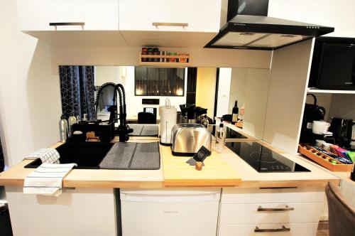 une cuisine avec un évier et un plan de travail dans l'établissement Appart Chill & Work - 50m Gare de Valenciennes, à Valenciennes