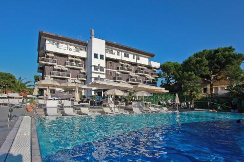 un hôtel avec une piscine en face d'un bâtiment dans l'établissement Hotel Delle Nazioni, à Lignano Sabbiadoro