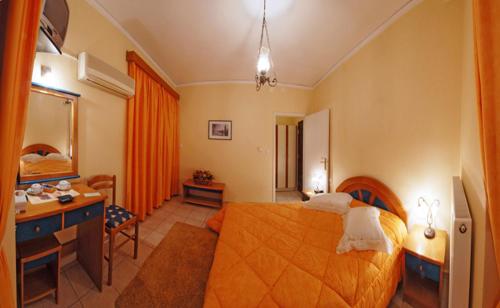 a hotel room with a bed and a desk and a bedroom at Hotel Marily in Pyrgos