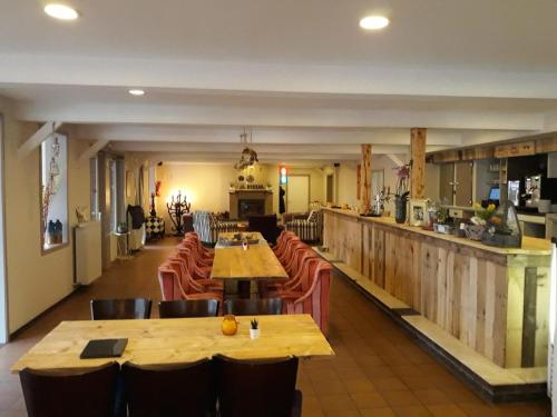 un restaurante con mesas y sillas de madera y una barra en Vakantie Boshuisje Meibloempje en Lanaken