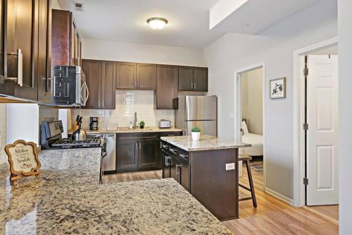 una cocina con armarios de madera y electrodomésticos de acero inoxidable en 4BR Classy & Radiant Apt in Wicker Park - Blackhawk 3F, en Chicago