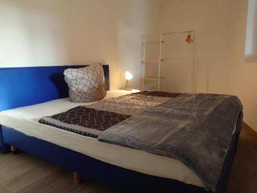 een slaapkamer met een groot bed met een blauw hoofdeinde bij Haus No. 5A in Demmin