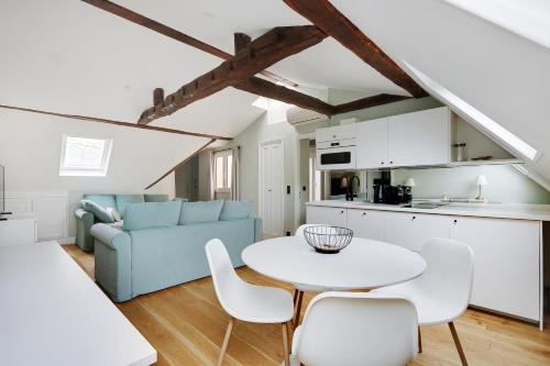 une cuisine et un salon avec une table et des chaises dans l'établissement Pick A Flat's Apartments in Opéra Saint Lazarre - Rue de l'Isly, à Paris