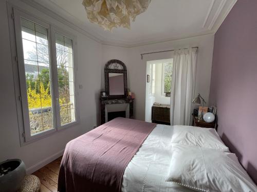 a bedroom with a bed and a mirror and windows at Maison du bonheur in Villiers-sur-Marne
