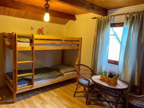 a room with a bunk bed and a table and chairs at Chata TRI GROŠE 3 in Námestovo