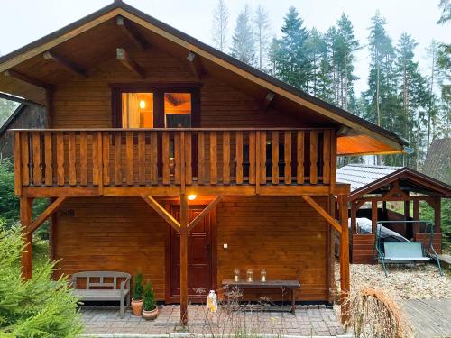 a large wooden cabin with a large deck at Chata TRI GROŠE 3 in Námestovo