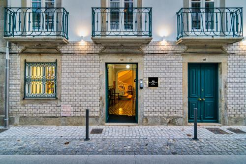 a building with two blue doors and two balconies at Flag Design Hotel in Viana do Castelo