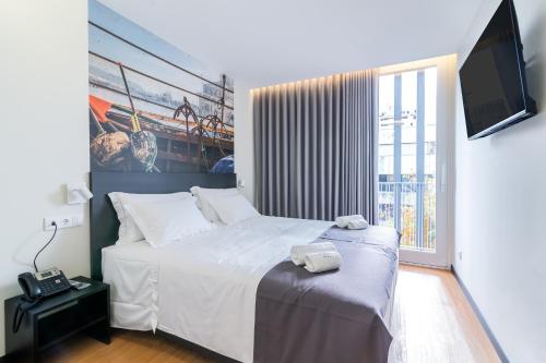 a bedroom with a bed and a large window at Flag Design Hotel in Viana do Castelo