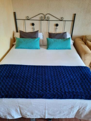 1 dormitorio con 1 cama grande con almohadas azules en Apartamento Sonia, en Torremolinos