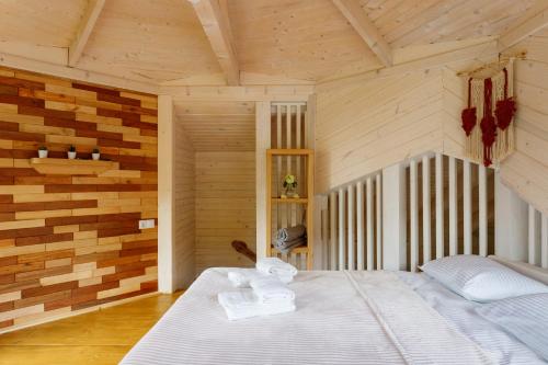a bedroom with a bed in a room with wooden walls at Хата Різьбяра - Закуток in Beloberëzka