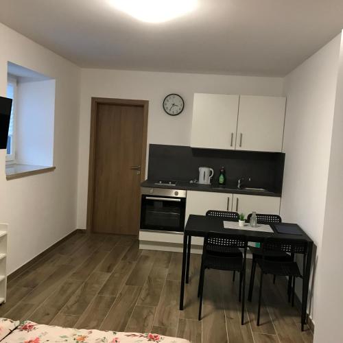 a kitchen with a table and a clock on the wall at Heimatliebe Bruckmaier in Neustadt an der Donau