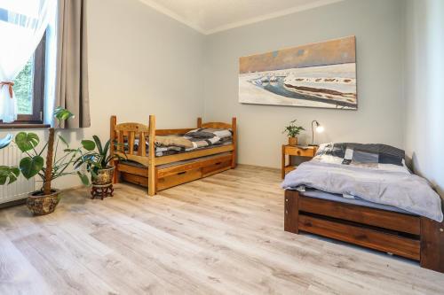 a bedroom with two beds and a potted plant at Villa 124 SPA & Sauna komfortowy apartament Beskidy in Bystra