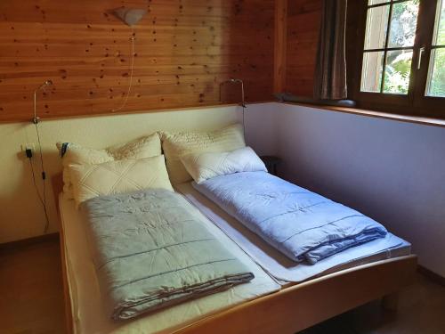 a bed in a room with pillows on it at Wallisblick in Blatten bei Naters