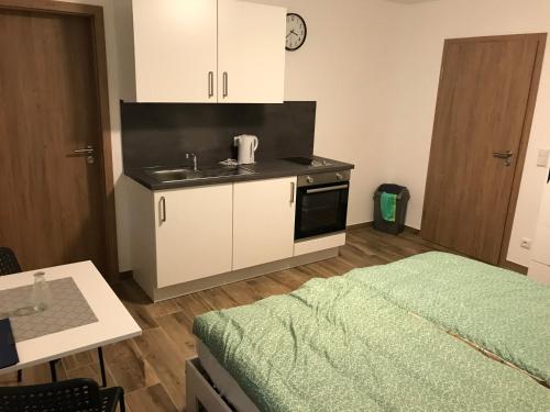 a small kitchen with a sink and a bed in a room at Heimatliebe Bruckmaier in Neustadt an der Donau