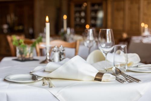 a table with a white table cloth with silverware and napkins at Meisser Hotel "superior" in Guarda