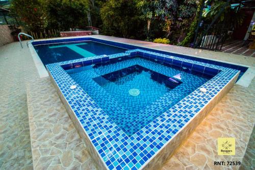 una piscina con azulejos azules en el suelo en Bosques de la Pradera, en Manizales