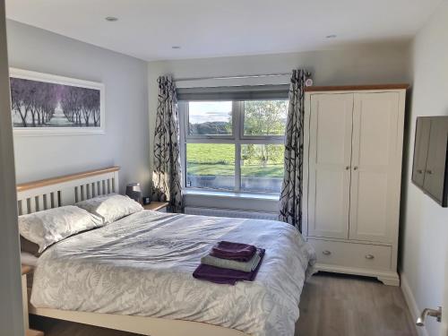 a bedroom with a large bed and a window at Cranfield Cottage by the Sea 4 star NITB approved in Kilkeel