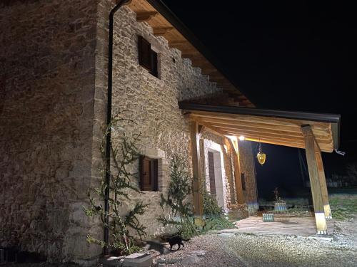 a stone house with a cat sitting in front of it at Masseria D'Achille in Castel di Sangro