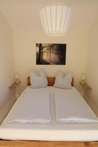 Cama en habitación con 2 almohadas blancas en Ferienwohnung Stöckl, en Grabenstätt