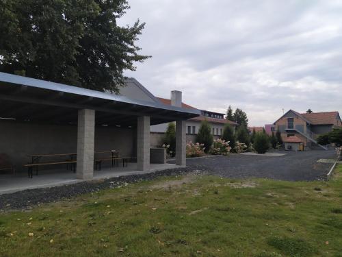 a pavilion with a bench and a building at Ubytování na statku Račice in Račice