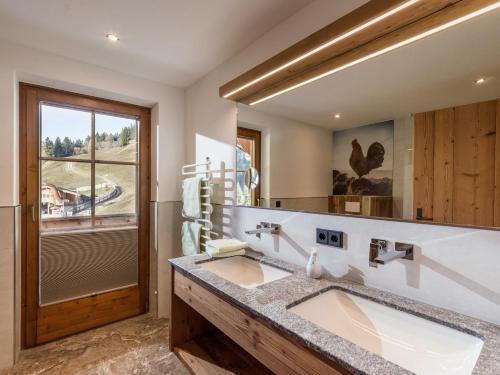 een badkamer met 2 wastafels en een grote spiegel bij Stöcklalm in Söll