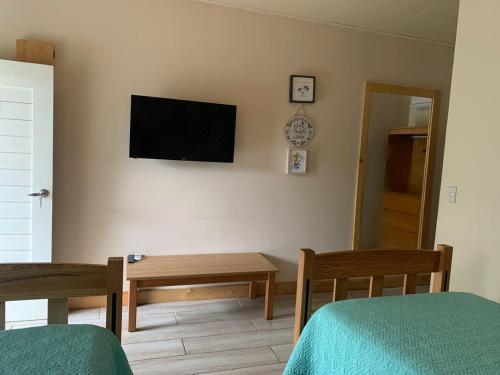 a room with two beds and a television on the wall at Hotel Las Palmas de OSA in Ciudad Cortés