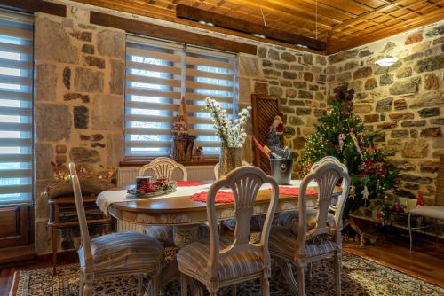 a dining room with a table and chairs and a christmas tree at Helene Eco Luxury Villa in Tsagarada