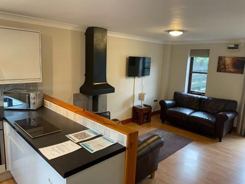 a kitchen and a living room with a stove at Rose Cottage in Camelford