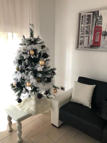 a christmas tree in a living room next to a couch at "CASA ROSI" Tel trequattrozero trentatre tredici seiquattrouno in Umbertide