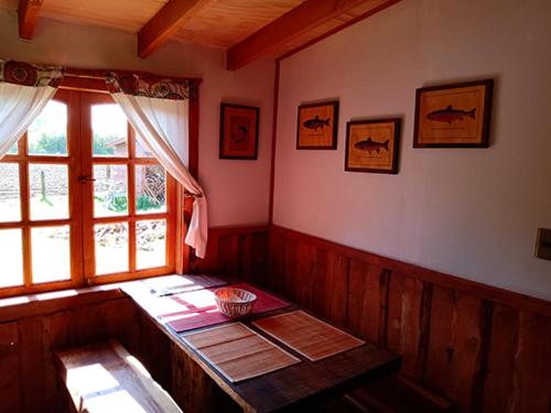 a room with a wooden table and a window at Casa del rio in Radal