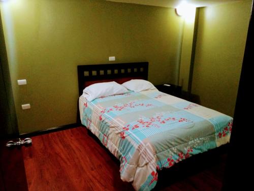 a bedroom with a bed in a room with green walls at Casa de Huéspedes Tu Parada en Cuenca in Cuenca