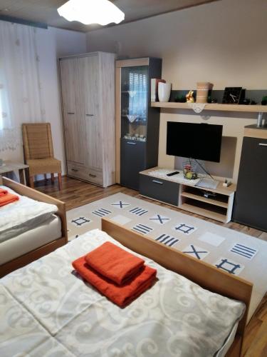 a bedroom with a bed with an orange towel on it at Apartman Kalinka in Gajić