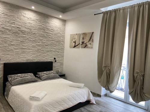 ein Schlafzimmer mit einem Bett und einer Ziegelwand in der Unterkunft Room27 in Taranto