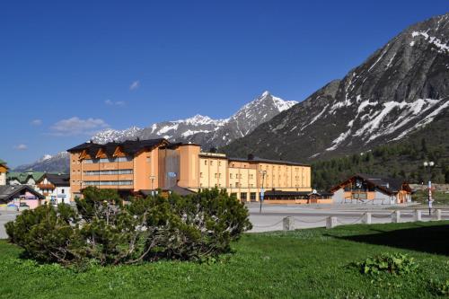 a large building with mountains in the background at Grand Hotel Miramonti in Passo del Tonale