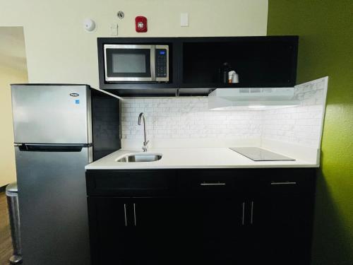 a kitchen with a refrigerator and a sink and a microwave at Quality Inn & Suites Lake Charles South in Lake Charles