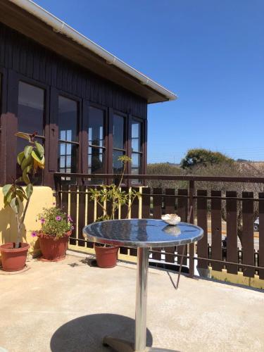 a blue table on a patio with a house at Hostal Kuyen in Pichilemu