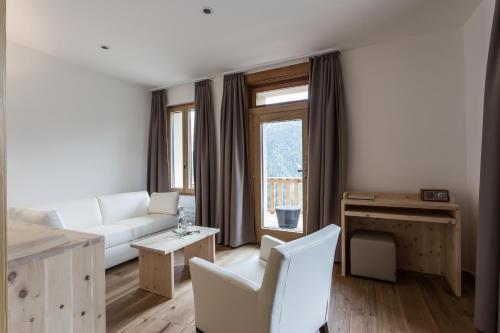 a living room with a white couch and a window at Meisser Hotel "superior" in Guarda