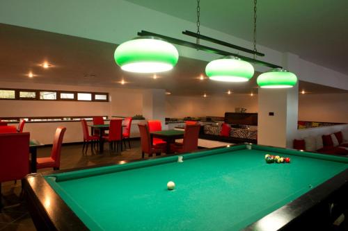 a pool table in a room with tables and chairs at Pizzomunno Vieste Palace Hotel in Vieste