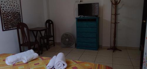 a bedroom with a bed and a television and towels at La Casa del Che Fernando in Lima