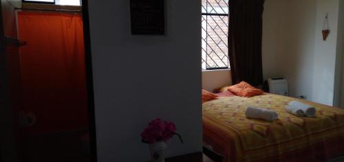 a bedroom with a bed with two pillows and a window at La Casa del Che Fernando in Lima
