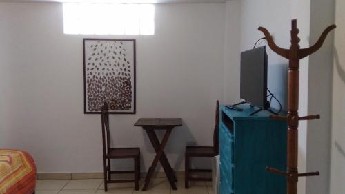 a room with a bed and a tv and a table at La Casa del Che Fernando in Lima